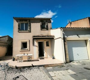 Façade de la maison avec garage, située dans une rue calme de Saint-Mamert-du-Gard