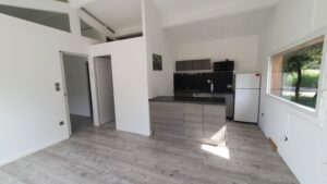 Cuisine ouverte aménagée dans la pièce principale d’une maison en bois à Calvisson
