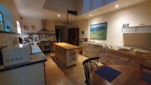 Cuisine aménagée avec accès direct à la cour, dans une maison de village à vendre à Calvisson
