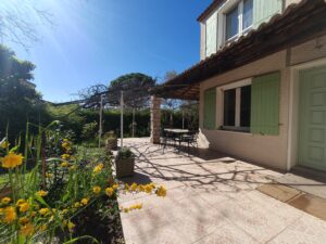 Terrasse extérieure ombragée attenante à la pièce de vie, dans une villa avec piscine à Clarensac