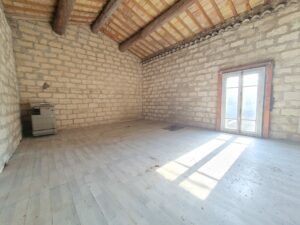 Potentiel atypique d’une pièce avec poutres et pierres apparentes dans un bien à rénover