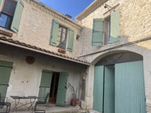 Façade en pierre et cour ensoleillée de la maison de village à vendre à Calvisson