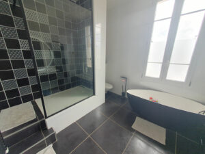 Salle de bain avec baignoire et douche italienne dans la maison à Cardet