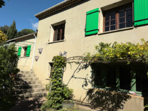 Vue de la façade côté piscine dans une maison à vendre à Anduze
